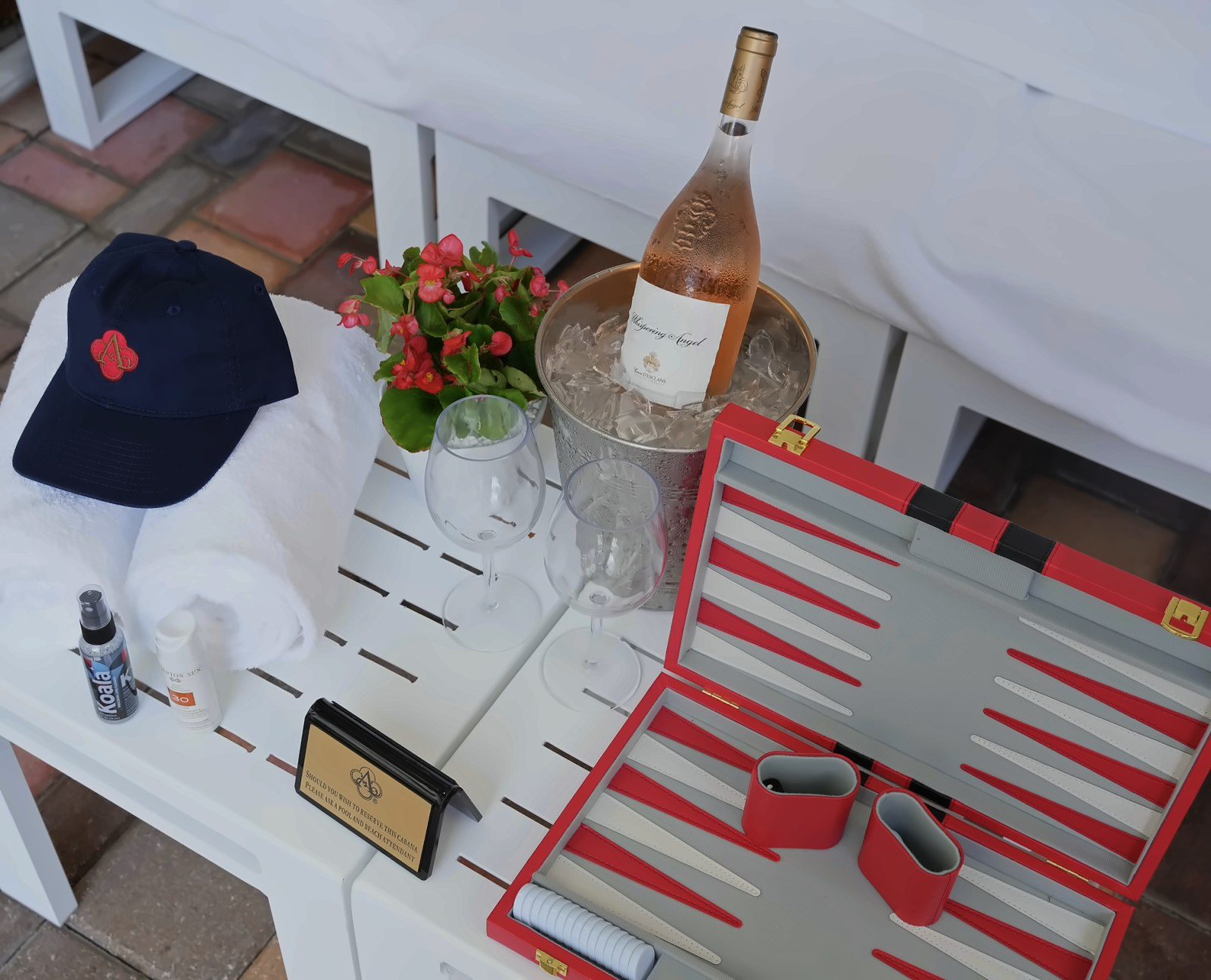 Acqualina cabana setup with rosé on ice, a branded cap and a backgammon set