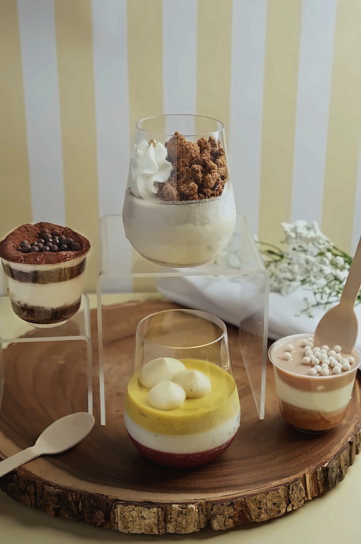 Sweet Epico layered dessert cups on a wooden board
